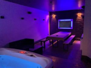 a room with purple lighting and a table and a bed at Saltrock luxury apartment in Blackpool