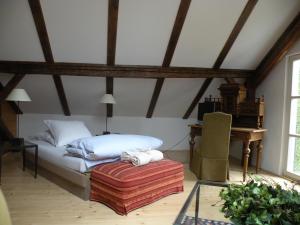 a bedroom with a bed and a table and a chair at Alte Posthalterei Zorneding in Zorneding