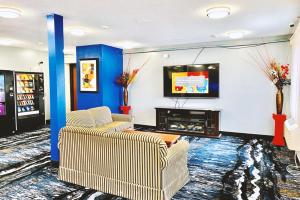 a living room with two chairs and a tv at Coratel Inn & Suites by Jasper Northfield in Northfield