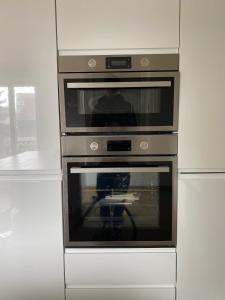 a kitchen with two ovens in a white wall at Superbe appartement Moderne Hyper centre de Vittel in Vittel