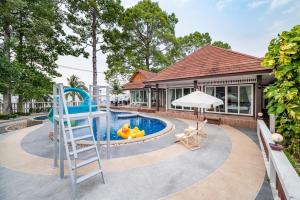 une maison avec une piscine avec une échelle et une aire de jeux dans l'établissement RimLay Beachfront Pool Villa, à Sattahip