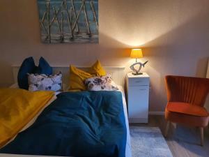a bedroom with a bed and a lamp and a chair at Bi Henning in Nordstrand