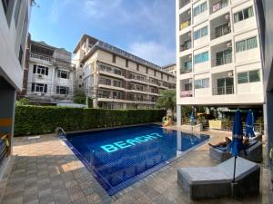 une piscine devant un bâtiment dans l'établissement Beach 7 Condo Pattaya 11, à Jomtien Beach