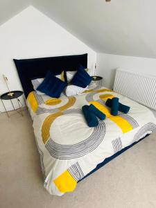 a large bed with blue and yellow pillows on it at Seabourne Scarborough Beautiful 2 bedroom 2 bathrooom Penthouse With Fabulous Seaview in Scarborough