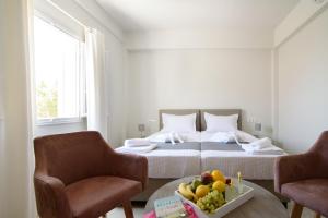 ペリッサにあるDe_naxia Suitesのベッドルーム1室(ベッド1台、テーブルの上にフルーツボウル付)