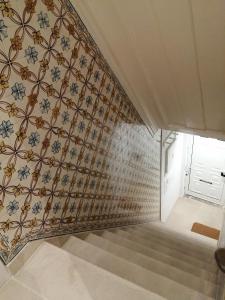 a stairwell with a patterned wall and a stair case at Casa do Coronel in Alcochete