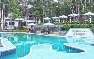 a swimming pool at a resort with umbrellas at Mt Hamiguitan Escape Resort in La Union