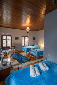 a bedroom with two beds and a wooden ceiling at Casa Calda in Syrrako