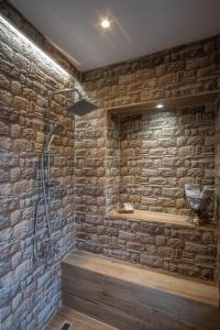 a bathroom with a stone wall and a shower at Casa Calda in Syrrako