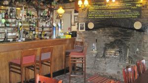 un bar con chimenea de piedra en un pub en Rose & Crown Hotel, en Bainbridge