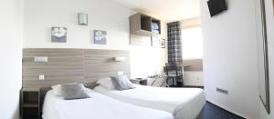 2 camas en una habitación de hotel con sábanas blancas en B&B HOTEL Sète Centre Gare en Sète