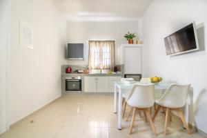 ペリッサにあるDe_naxia Suitesの白いキッチン(白いテーブルと椅子付)