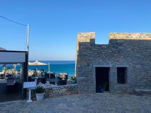 a stone building with a patio with the ocean in the background at Plaka Bleu Apartments in Pláka