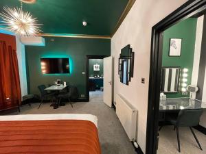 a bedroom with green walls and a bed with a desk at The 25 Boutique B&B - Adults Only in Torquay
