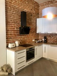 a kitchen with white cabinets and a brick wall at Strada Ion I. C. Brătianu Nr.24 in Cluj-Napoca