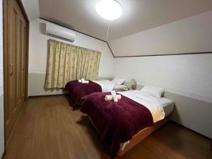 a hotel room with two beds and a window at Hakuba Mountain Chalet in Hakuba