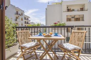 een houten tafel met 2 stoelen op een balkon bij Primopiano Luxury Accommodations in Vieste