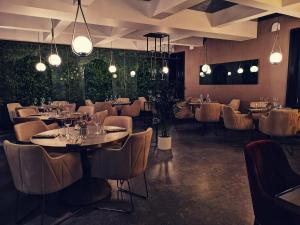 a restaurant with tables and chairs and lights at Hotel MOREA in Ljubljana