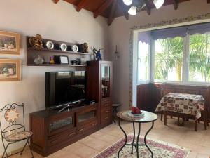 a living room with a television and a table at Apartamento MAR Y TEIDE in Sauzal