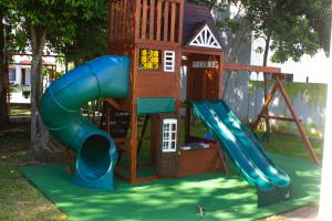 um parque infantil com escorrega e uma casa de brincar em Marsella Home em Playa del Carmen