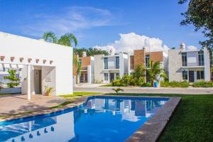 a house with a swimming pool in front of a building at Marsella Home in Playa del Carmen