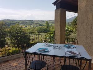 a white table on a balcony with a view at MAISON PROVENCE AVEC PISCINE PRIVATIVE in Nyons