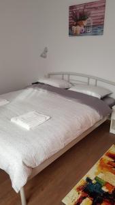 a bedroom with a bed with a white blanket and a rug at Apartament 4 Budiu in Târgu-Mureş