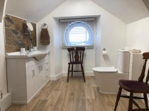 a bathroom with a sink and a toilet and a window at The Haven in Holyhead