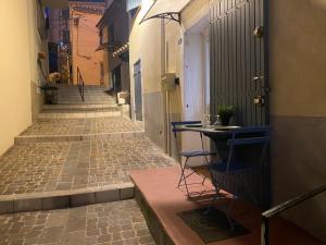 an alley with a table and chairs on a street at Petit Cocon cosy au cœur du village d'Allauch in Allauch