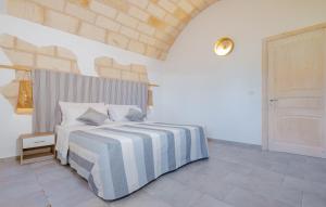 リド・マリーニにあるVilla Le Tregi di Claudioのベッドルーム1室(青と白のストライプの毛布付きのベッド1台付)