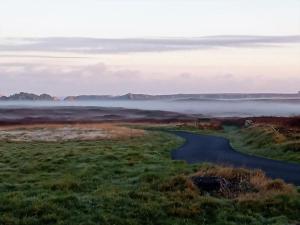 a river in the middle of a field with fog at La Lanterne du Bout du Monde in Ouessant
