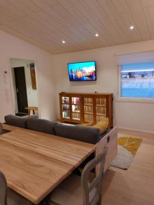 a living room with a couch and a tv on the wall at Arctic River Chalet in Rovaniemi