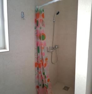 eine Dusche mit einem farbenfrohen Duschvorhang im Bad in der Unterkunft Apartament 5 Budiu in Târgu Mureș