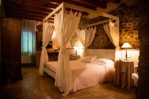 a bedroom with a canopy bed with curtains at Villa dei Mulini in Volta Mantovana