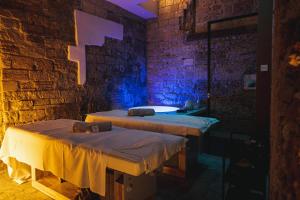 2 camas en una habitación con una pared de piedra en PALAZZO SANTAMARINA Luxury Suite & Spa en Palermo
