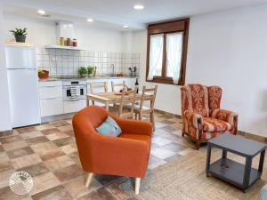 een woonkamer met een stoel en een tafel en een keuken bij Casa Zunbeltz de 3 habitaciones en plena montaña in Lezáun