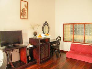 Vimean Sovannaphoum Resort في باتامبانغ: غرفة معيشة مع مكتب وأريكة حمراء