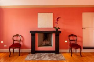 a living room with a fireplace and two chairs at Tenuta San Giorgio in Serravalle Scrivia