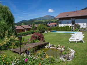 a garden with a bench and flowers and a pool at Naturhotel Edelweiss in Terento