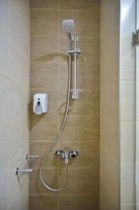 La salle de bains est pourvue d'une douche avec un pommeau de douche. dans l'établissement City Pearl Dntwn Apts, à Héraklion