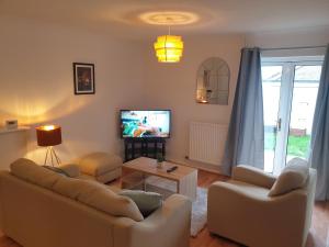 a living room with two couches and a tv at Stylish 3 Bedroom House with Free Parking in Norwich