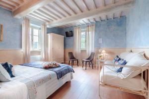 a bedroom with a bed and a table and chairs at Casolare dei Colli, Panoramic Private Pool, Lavish Interiors and a Gourmet Kitchen in Camaiore +74 photos