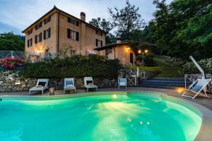 a large swimming pool in front of a house at Casolare dei Colli, Panoramic Private Pool, Lavish Interiors and a Gourmet Kitchen in Camaiore
