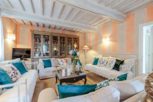 a living room with two white couches and a table at Casolare dei Colli, Panoramic Private Pool, Lavish Interiors and a Gourmet Kitchen in Camaiore