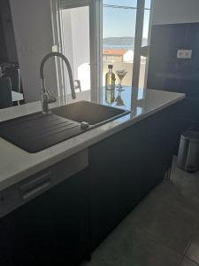 eine Küchentheke mit einem Waschbecken und einem Fenster in der Unterkunft Apartment Istuk in Kaštela