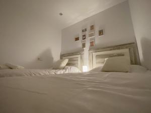 two beds in a room with white walls at La Casita de Colores de Alicia in Cuenca