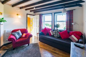 a living room with a couch and a chair at Altquhur Byre in Drymen