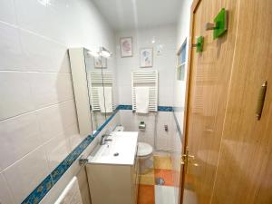 a bathroom with a sink and a toilet and a mirror at La Casita de Colores de Alicia in Cuenca
