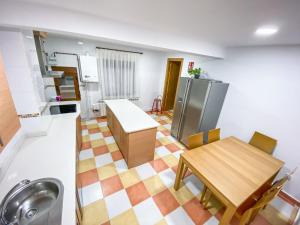 eine Küche und ein Esszimmer mit einem Tisch und einem Waschbecken in der Unterkunft La Casita de Colores de Alicia in Cuenca