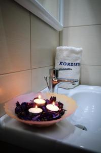 a plate with candles on top of a bathroom sink at Kordistos Hotel in Kefalos